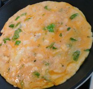 Omelette mit Zutaten stocken lassen