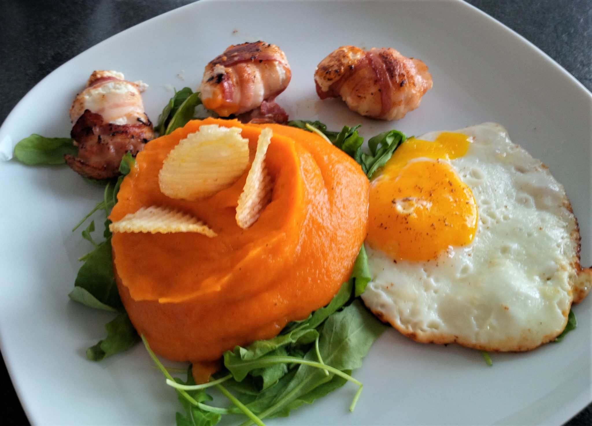 Karottenpüree auf Rucola mit Spiegelei &amp; Ziegenkäsetaler in Speck